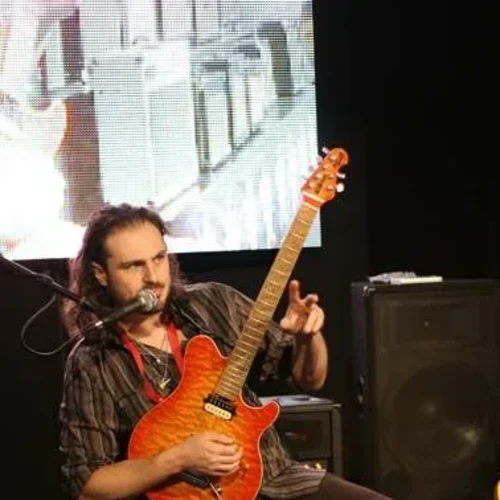 Bandshop GmbH auf der Musikmesse Frankfurt – Gitarrist mit roter Gitarre im Sitzen