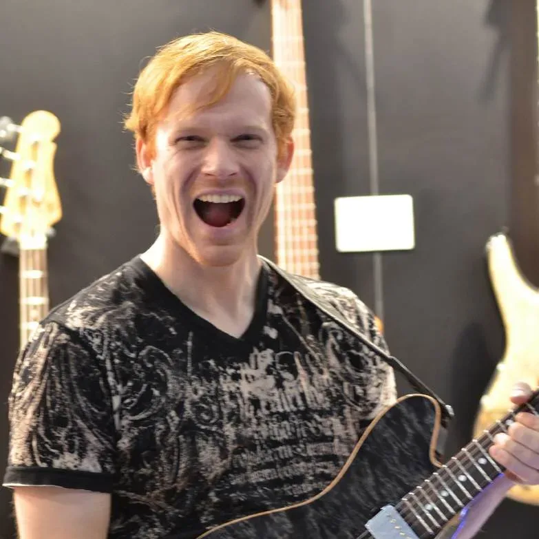 Bandshop GmbH auf der Musikmesse Frankfurt – Gitarrist lacht mit schwarzer Gitarre