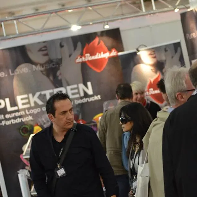 Bandshop GmbH auf der Musikmesse Frankfurt – Besucher am Bandshop-Stand vor der Plektren-Wand