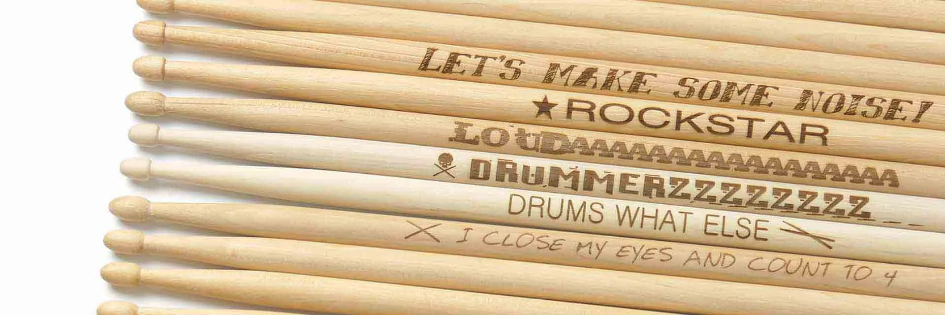 Nahaufnahme lasergravierter Drumsticks mit verschiedenen Schriftzügen